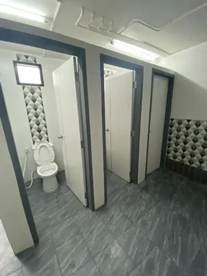 a bathroom with a toilet and two stalls with doors at NIJ Lady dorm in Bangkok