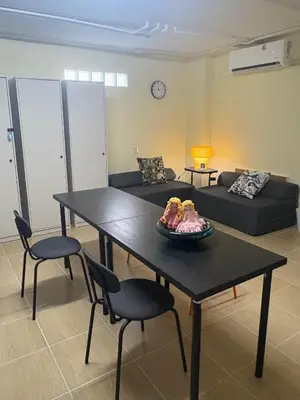 a living room with a table and chairs and a couch at NIJ Lady dorm in Bangkok