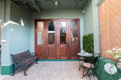 a porch with a wooden door and a table and a bench at Bangkok Villa for Big Groups 3Mins walk MRT in Samphanthawong