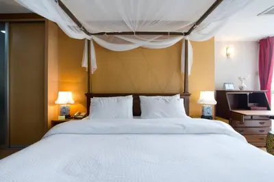 a bedroom with a large white bed with two lamps at 1br with Pool Gym near BTS Phrom Phong in Khlong Toei