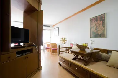 a living room with a couch and a tv at 1br with Pool Gym near BTS Phrom Phong in Khlong Toei