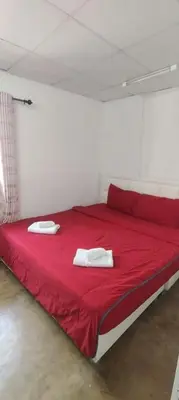 a red bed with two white towels on top of it at Double Room-C102 in Bangkok