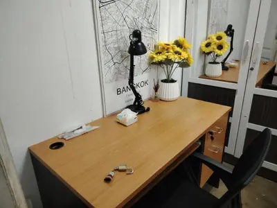a wooden desk with a lamp and flowers on it at Double Room-C102 in Bangkok