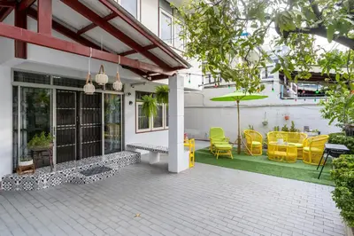 a patio with yellow chairs and an umbrella at 110 House 4Bedroom in Ban Zong Katiam