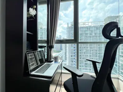 a laptop sitting on a desk in front of a window at Tranquil Apt 2 BR - Ultra Fast Wifi - BTS On Nut in Bangkok