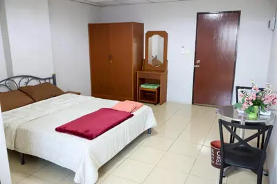 a bedroom with a bed and a table with a mirror at DD House Apartment in Bangkok