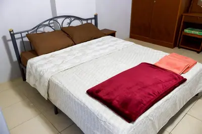 a bed with a red blanket on top of it at DD House Apartment in Bangkok