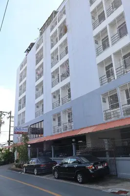 two cars parked in front of a large white building at DD House Apartment in Bangkok
