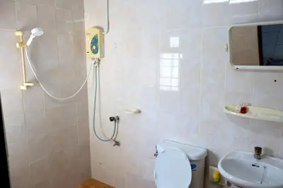 a bathroom with a shower and a toilet and a sink at DD House Apartment in Bangkok