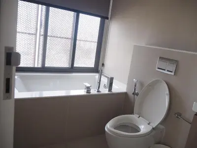 a bathroom with a toilet and a tub and a window at Circle Sukhumvit31 Bangkok #2BR #5ppl in Bangkok