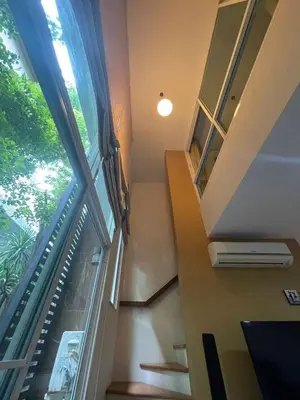 a staircase in a house with a large window at Loft at sanambinnam in Ban Bang Talat
