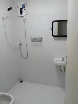 a white bathroom with a shower and a toilet at xx GO INN Siriraj BKK โกอินน์ ศิริราช in Bangkok Noi