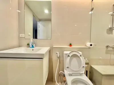 a white bathroom with a toilet and a sink at Central Living Ploenchit in Bang Kapi