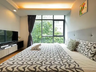 a bedroom with a large bed with a large window at Central Living Ploenchit in Bang Kapi
