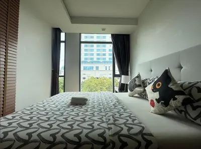 a bedroom with a large bed with a large window at Central Living Ploenchit in Bang Kapi
