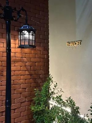 a light next to a brick wall with a sign at Thai Loft \u6cf0\u95a3 in Bangkok