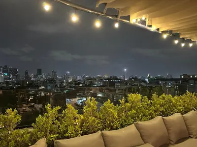 a view of a city at night with a couch at Thai Loft \u6cf0\u95a3 in Bangkok