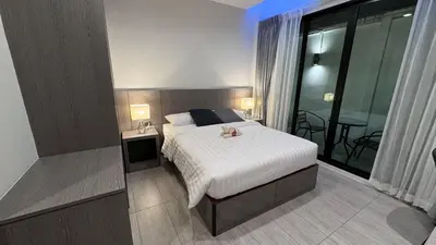a bedroom with a bed and a large window at The Kite Hotel Bangkok in Bangkok