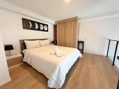 a bedroom with a bed with two towels on it at BTS onnut loft quiet room Netflix Rooftop bar in Bangkok
