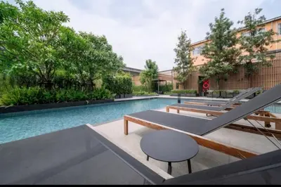 a swimming pool with several tables and a chair at BTS onnut loft quiet room Netflix Rooftop bar in Bangkok