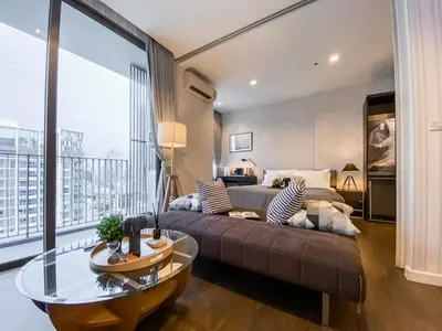 a living room with a couch and a large window at Modern High-Rise 1BR - Ultra Fast Wifi - Sathorn in Bangkok
