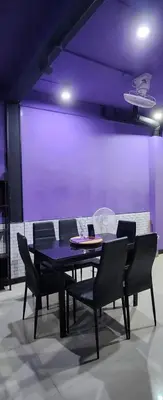 a dining room table with chairs and a purple wall at Ber Ben House in Bang Su
