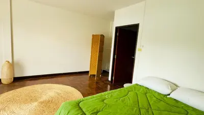a bedroom with a bed with a green comforter at Creative Bangkok Bed in Sathani Bang Khen
