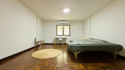 a bedroom with a bed and a rug on a wooden floor at Creative Bangkok Bed in Sathani Bang Khen