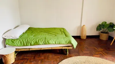 a bed with a green comforter in a room at Creative Bangkok Bed in Sathani Bang Khen