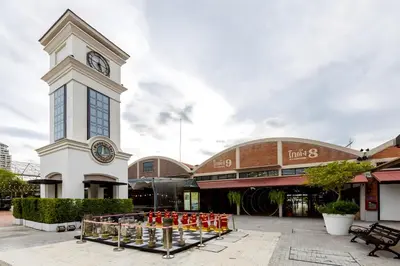 a large building with a clock tower in front of it at XX GO INN Asiatique BKK - โกอินน์ เอเชียทีค เจริญกรุง in Godown