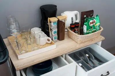 a wooden shelf with glasses and other items on it at Non Inn Entire Historic 5 Bedroom Riverside Shophouse near ICONSIAM for Families and Groups in Bang Rak