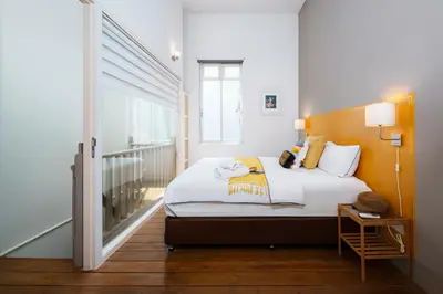 a bedroom with a bed and a window at Non Inn Entire Historic 5 Bedroom Riverside Shophouse near ICONSIAM for Families and Groups in Bang Rak