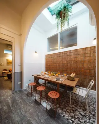 a dining room with a table with stools at Non Inn The Post Spacious King Room with Sofa Bed and Living Area near Riverside and ICONSIAM in Bang Rak