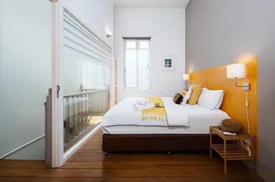 a bedroom with a bed and a window at Non Inn The Post Spacious King Room with Sofa Bed and Living Area near Riverside and ICONSIAM in Bang Rak