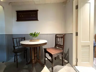 a table and two chairs in a room at Non Inn The Diamond Artisan and Barber 4 Bedroom Riverside Retreat with King and Twin Rooms in Bang Rak