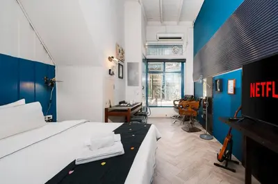 a bedroom with a bed and a desk in it at Non Inn The Post and Barber 3 Bedroom Riverside Shophouse with King and Twin Rooms in Bang Rak
