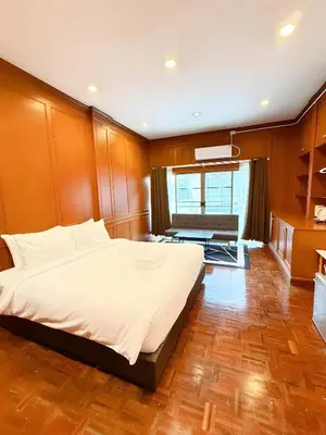 a bedroom with a large bed and a living room at Stay On Sukhumvit Soi 11 - สเตย์ ออน สุขุมวิท 11 in Makkasan