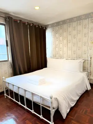a bedroom with a bed with white sheets and a window at Stay On Sukhumvit Soi 11 - สเตย์ ออน สุขุมวิท 11 in Makkasan