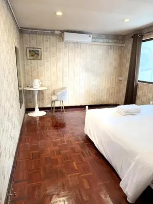 a bedroom with a bed and a table and a chair at Stay On Sukhumvit Soi 11 - สเตย์ ออน สุขุมวิท 11 in Makkasan