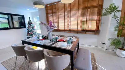 a dining room with a table and chairs and a christmas tree at Private Pool Villas Sukhumvit 26 Near BTS Phrom Phong and EmSphere in Bangkok