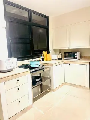 a kitchen with white cabinets and a stove top oven at Private Pool Villas Sukhumvit 26 Near BTS Phrom Phong and EmSphere in Bangkok