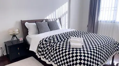 a bedroom with a black and white checkered bed at Private Pool Villas Sukhumvit 26 Near BTS Phrom Phong and EmSphere in Bangkok