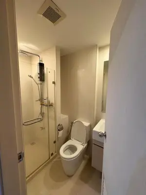 a small bathroom with a toilet and a shower at Welcome to warm room here have gym saona Netflix in Bangkok