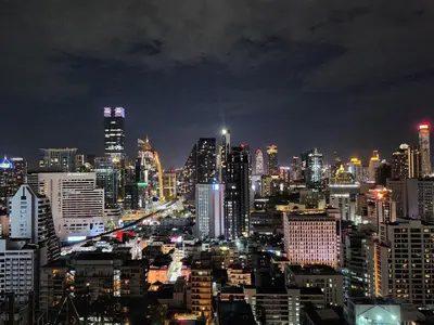 a city lit up at night with at Kuma House Sukhumvit in Bangkok