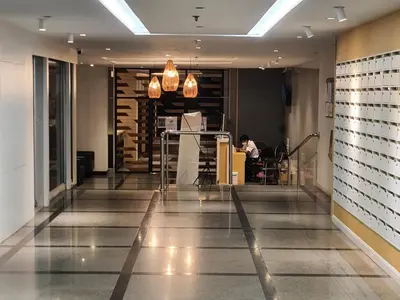 a lobby with a person sitting at a table in a restaurant at Kuma House Sukhumvit in Bangkok