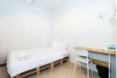 a bed in a room with a desk and a chair at xx เดอะ ฮิดเด้น ตรอก ข้าวสาร The Hidden Khaosan in Bangkok