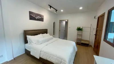 a bedroom with a large bed with white sheets at Baan Yard - More than 5 nights stay in Bangkok