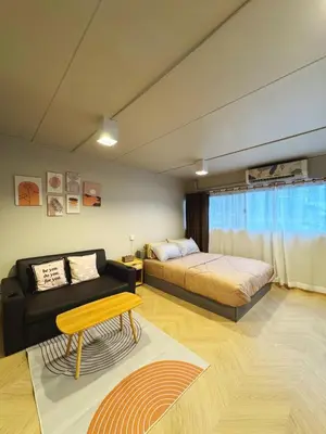 a bedroom with a bed and a couch and a table at MoonStay C5 Impactarena-Donmuang-FreeSpeedWifi in Thung Si Kan