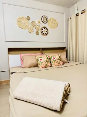 a bedroom with two beds and a wall with clocks at MoonStay C1 Impact Arena Muangthongthani-Donmuang-FreeSpeedWifi in Nonthaburi