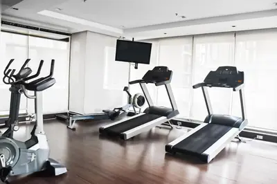 a gym with cardio machines and a flat screen tv at Modern 2 Bed Executive Unit - 5min to Nana BTS in Bangkok